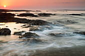 Sunrise over coastal rocks, Salalah, Oman