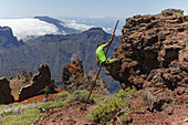 Mann klettert mit dem Kanarischen Hirtenstab, Salto del Pastor Canario, Kraterrand der Caldera de Taburiente, UNESCO Biosphärenreservat, La Palma, Kanarische Inseln, Spanien, Europa