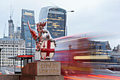 The emblem of City of London with a traditional red bus and City’s skyscrapers on background, London Bridge, London, Great Britain, UK