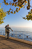 Couple admiring Lake Constance from the promenade. Meersburg, Baden-Württemberg, Germany.