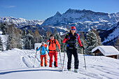 Three persons backcountry skiing ascending to Medalges, Fanes range in background, Medalges, Natural Park Puez-Geisler, UNESCO world heritage site Dolomites, Dolomites, South Tyrol, Italy