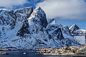 Verschneite Berge mit Fischerhäuser und Hafen von Hamnoy, Hamnoy, Lofoten, Nordland, Norwegen
