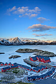 Fischerhäuser mit Küste und verschneiten Bergen, Lofoten, Nordland, Norwegen