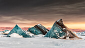 Icebergs on the sea ice off Spitsbergen east coast, Svalbard, entrapped in the fast ice.