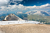 a beautiful landscape from the top of the Marmolada with a group of hikers walking on a glacier, Trento province, Trentino Alto Adige, Italy