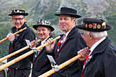 Four traditionally dressed locals of Zermatt play the Alphorn in front of the Matterhorn mountain.     With the passing of time, the alphorn almost totally disappeared as an instrument used by Swiss shepherds. It was only with the romanticism of the 19th 
