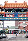 Side view of runner jogging through Chinatown, Seattle, Washington State, USA