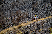 Biker pushing bicycle up hillside dirt road, Tenango, State of Mexico, Mexico