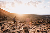 Woman photographing scenery with sand dunes at sunset, Tenerife, Canary Islands, Spain