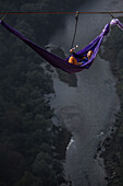 Side view of person lying in hammock and hanging on high line, Tijesno Canyon, Banja Luka, Bosnia and Herzegovina
