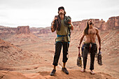 Front view of two rock climbers looking up while preparing to climb in Moab, Utah, USA