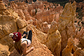 Female hiker sitting on edge of rock at Bryce Canyon National Park, Utah, USA