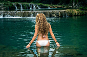 Rear view of young woman in bikini in waters of Semuc Champey, Guatemala