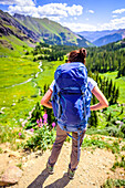 Rear view shot of female backpacker looking out over Ice Lakes Basin, Ice Lakes Trail, Colorado, USA