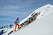 Frau auf Skitour steigt zum Hühnerkopf auf, Hohe Tauern im Hintergrund, Hühnerkopf, Berchtesgadener Alpen, Salzburg, Österreich