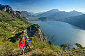 Mann und Frau wandern, Gardasee und Gardaseeberge im Hintergrund, Pregasina, Gardasee, Gardaseeberge, Trentino, Italien