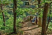 Man and woman sitting at vista-point in forest, Peterskanzel, Albsteig, Black Forest, Baden-Wuerttemberg, Germany