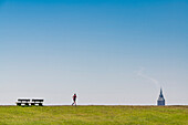 Joggerin auf dem Deich Richtung Westturm, Wangerooge, Ostfriesland, Niedersachsen, Deutschland