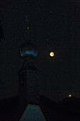 Blood Red Moon in the lunar eclipse 2018; in the front of the bell tower of the church of almau for overseas