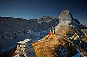 two women having a break on the ridge of Schafjoechl, Lamsenspitze in the back,  Eastern Karwendel Range, Tyrol, Austria