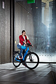 Young  woman in front of a moder glass facade, Munich, bavaria, germany