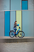 Young  woman in front of a moder glass facade, Munich, bavaria, germany