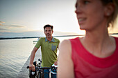 couple with Bikes on a jetty during bicycle tour, Ambach, bavaria, germany