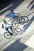 Young  woman young man on eBikes downtown, Munich, bavaria, germany