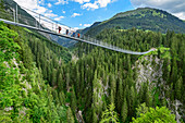 Several persons walking on suspension bridge, Holzgau, Lechweg, valley of Lech, Tyrol, Austria