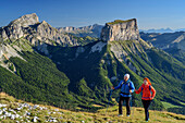 A man and a woman to climb up to the Tête Chevalier, Grand Veymont and Mont Aiguille in the background, Tête Chevalier, Vercors, Dauphine, Dauphine, Isère, France