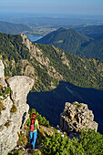 Frau beim Wandern steigt von der Aiplspitze ab, Aiplspitze, Mangfallgebirge, Bayerische Alpen, Oberbayern, Bayern, Deutschland