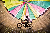 A dangerous motorbike carnival sideshow featuring a stunt biker takes life risk running his bike along the wall of a large wooden well known as `Mrittu Kup' or `Moron Kup' Poradah Mela near bramahputra River in Gabtoli upazila of Bogra district. This perf