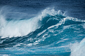 A large wave breaks against strong winds which blow the spray from the top, Atiu, Cook Islands, South Pacific