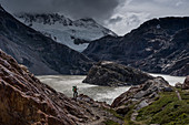 A hiker looks out over Lake Electrico with glacier in the background, Los Glaciares National Park, Patagonia, Argentina