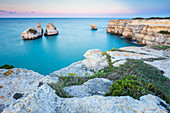 The Two Sisters stacks in front of the shore of Torre dell'Orso. Melendugno, province of Lecce, Salento, Apulia, Italy.
