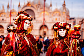 Mann und Frau im Kostüm und mit Maske beim Venedig-Karneval, Marktplatz San Marco (Markusplatz), Venedig, Venetien, Italien