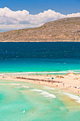 People on the narrow stretch of white sand which divides Simos beach, Elafonissos, Laconia Region, Peloponnese, Greece