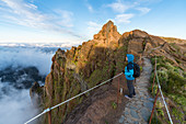 Woman admiring the view from PR1 trail. Pico do Arieiro, Funchal, Madeira region, Portugal.