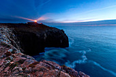Sunset frames the lighthouse overlooking the Atlantic Ocean Cabo De Sao Vicente Sagres Algarve Portugal Europe