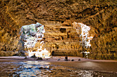 Rock cave with beach and with two holes in the ceiling, at Benagil, Algarve, Portugal