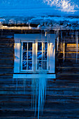 Fenster eines Holzhauses bei Heggenes im Winter, Norwegen
