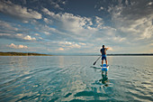 Junger Mann beim Stand Up Paddling auf dem Starnberger See, Bayern, Deutschland