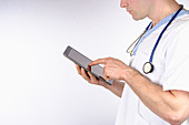 Doctor using digital tablet against white background
