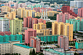 Workers' Party Monument amid painted blocks of flats, seen from Juche Tower, Pyongyang, North Korea, Asia