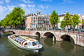 Canal tour boat and bridges at the junction of Leidsegracht Canal and Keizergracht Canal, Amsterdam, North Holland, Netherlands, Europe