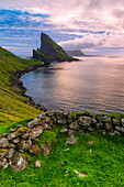 Sunset on the calm ocean and Drangarnir rock, Vagar island, Faroe Islands, Denmark, Europe