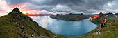 Wanderer auf den Klippen, mit Blick zu den Fjorden, Funningur, Eysturoy-Insel, Färöer, Dänemark, Europa