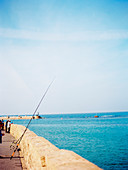 Side view of people fishing on seashore in the old city of Jaffa in Tel Aviv, Israel