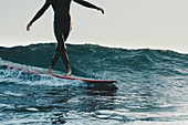 Surfer im Neopränanzug auf Surfbrett