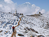 Hiker walking in snowy landscape of mountain pass in Nepalese Khumbu valley, Pheriche, Nepal